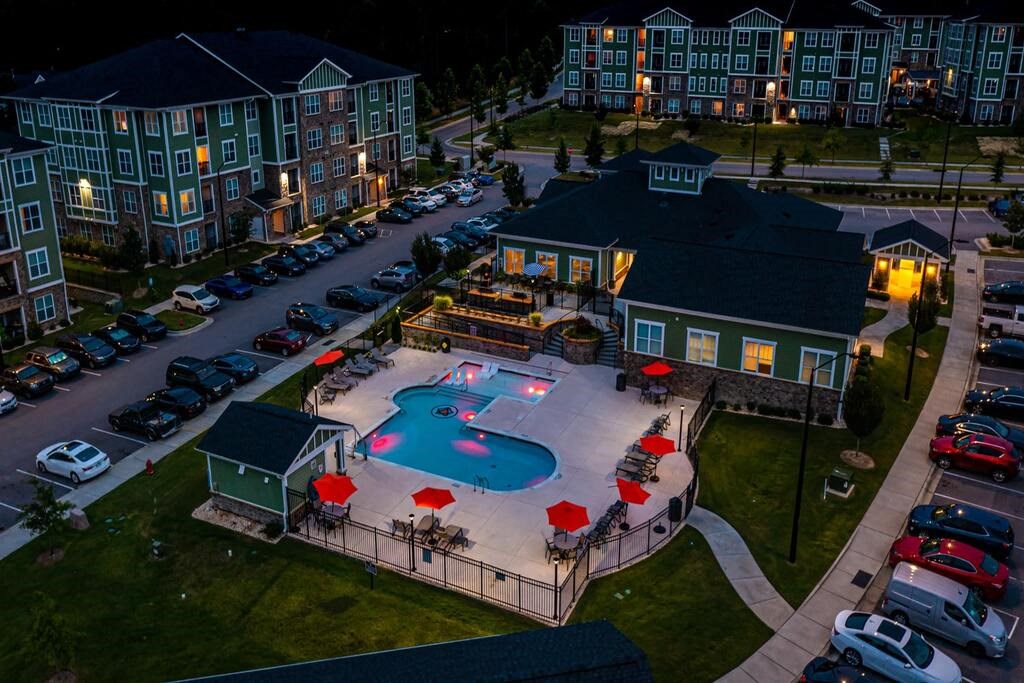 A large building with a pool in front of it at Foxwood Apartments, Raleigh-Durham, 27616