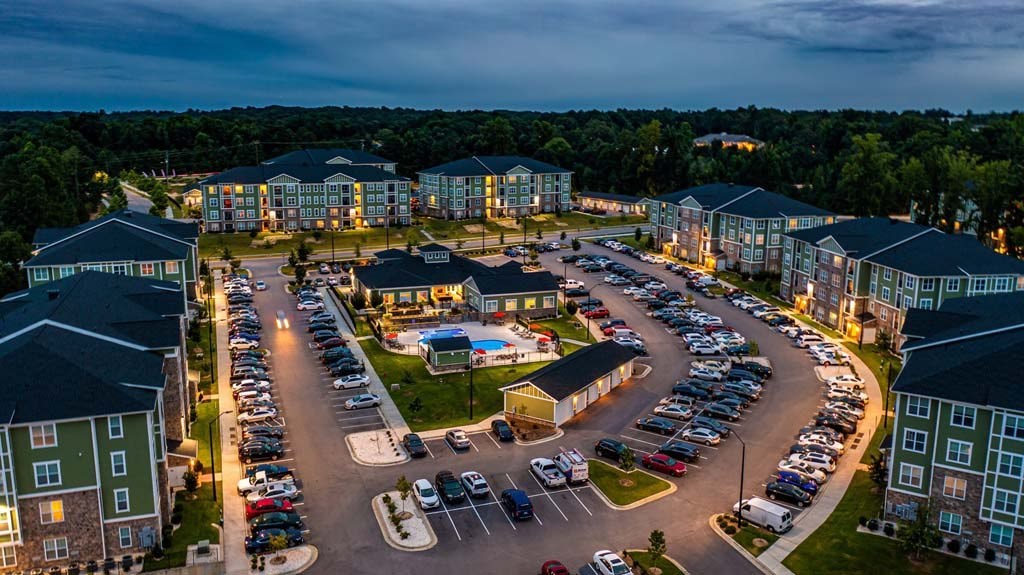 A parking lot is surrounded by apartment buildings. at Foxwood Apartments, North Carolina