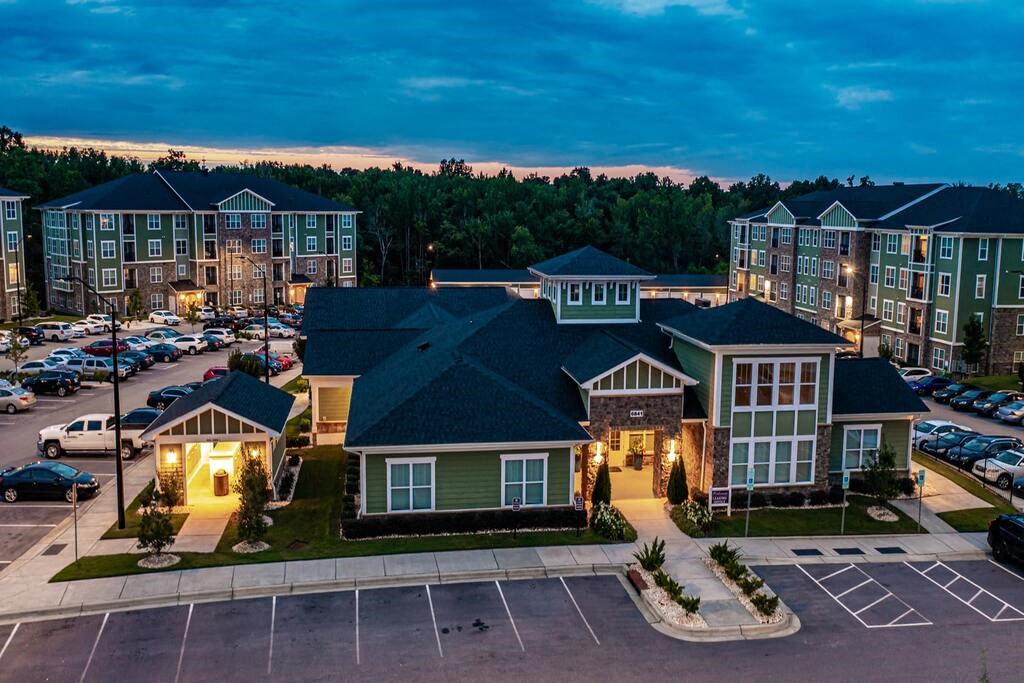 A parking lot in front of a building with a green roof at Foxwood Apartments, Raleigh-Durham, 27616
