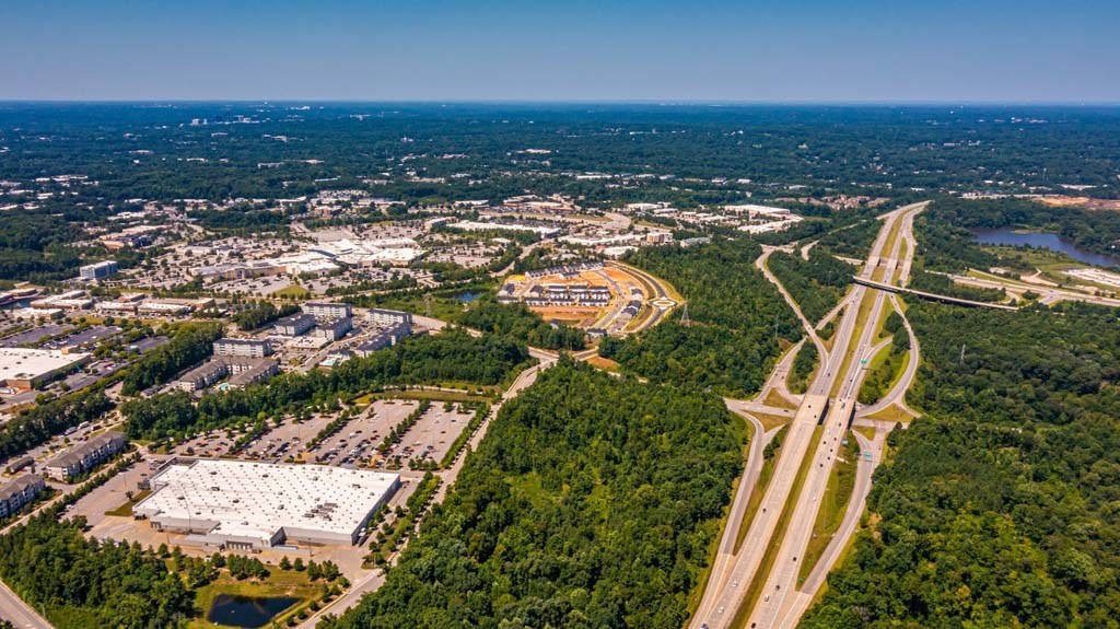A highway interchange with a large white building to the left at Foxwood Apartments, North Carolina