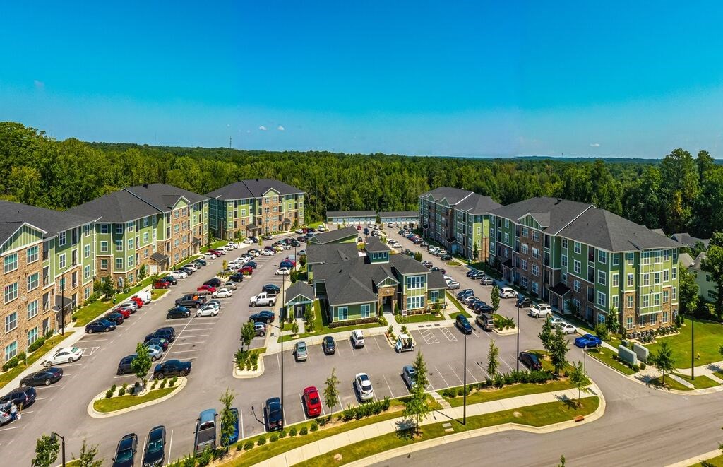A large apartment complex with a parking lot in front at Foxwood Apartments, Raleigh-Durham, NC, 27616