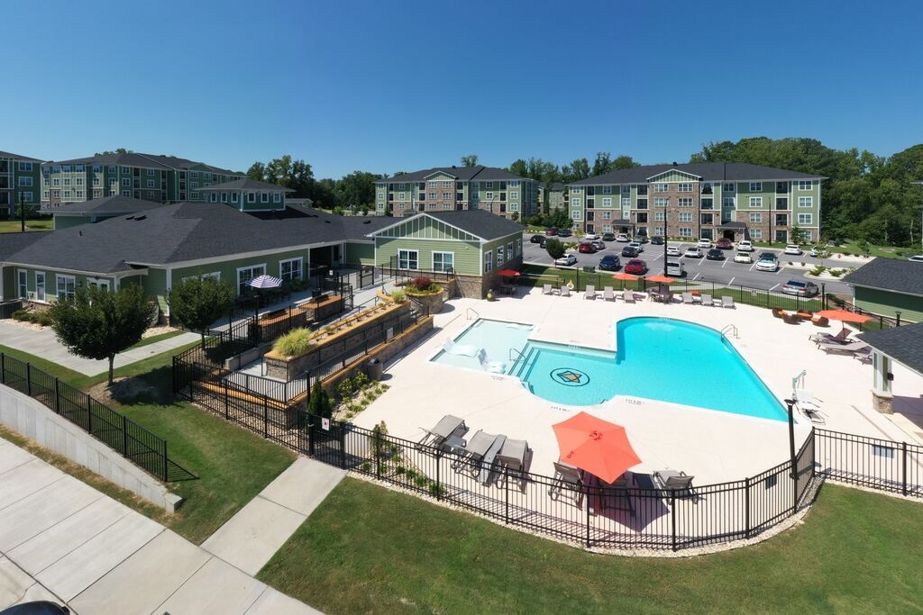 A large swimming pool surrounded by a black fence and several lounge chairs at Foxwood Apartments, Raleigh-Durham, NC, 27616