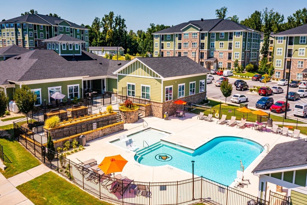 A large swimming pool surrounded by a fence and chairs at Foxwood Apartments, Raleigh-Durham, 27616