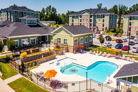 A large swimming pool surrounded by a fence and chairs.