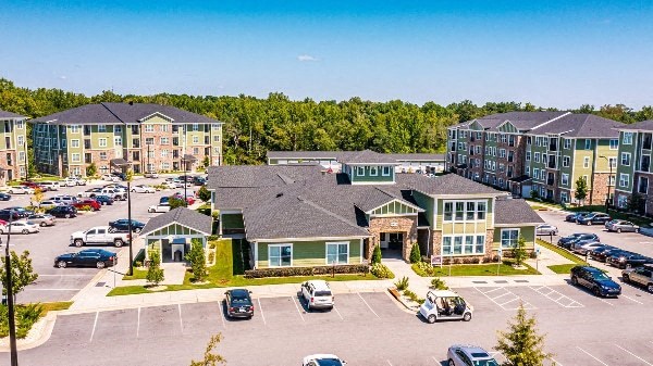 A parking lot with cars and a building in the background at Foxwood Apartments, North Carolina