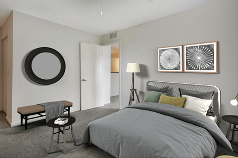 Virtually staged bedroom with wall mounted mirror, night stands, desk lamps, bed, bench, and wall art