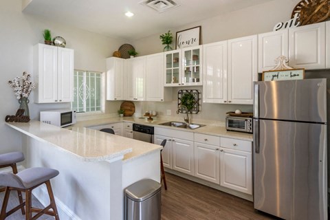 A modern kitchen with white cabinets and stainless steel appliances.