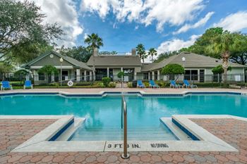 Swimming pool lounge seating, sun deck, with clubhouse in the background