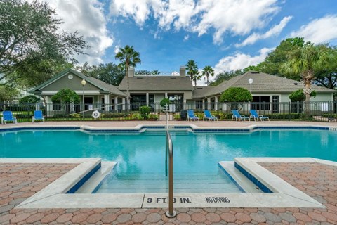 Swimming pool lounge seating, sun deck, with clubhouse in the background