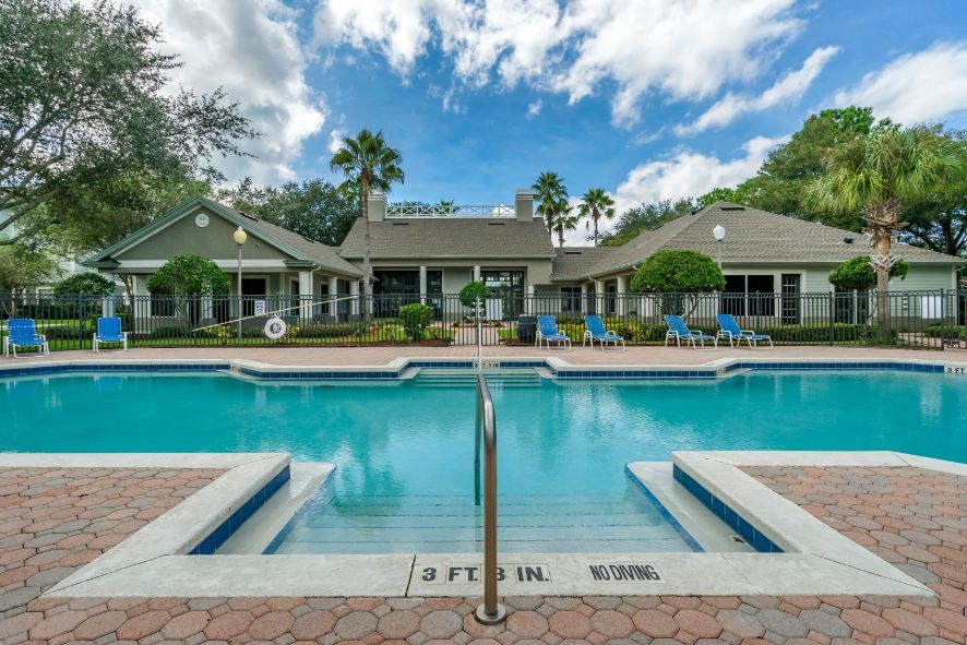 Swimming pool lounge seating, sun deck, with clubhouse in the background