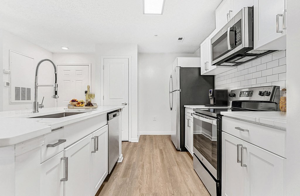 A kitchen with white cabinets and appliances. at The Grayson Apartment Homes, Charlotte, 28262