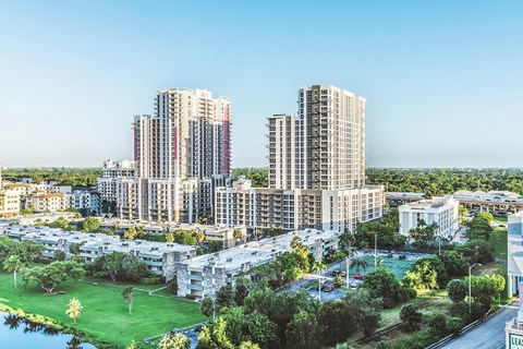 A large residential complex with a pool and a green area.