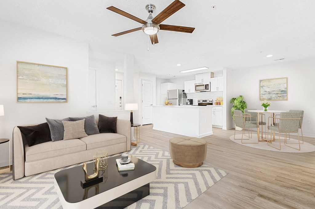 A living room with a beige couch, a coffee table, and a ceiling fan. at The Grayson Apartment Homes, Charlotte, 28262