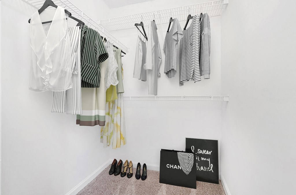 A room with clothes hanging and a pair of shoes on the floor The Grayson Apartment Homes, Charlotte, 28262