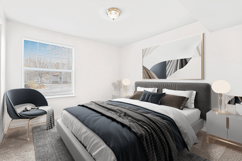 Virtually staged bedroom. Carpeted bedroom with grey and tan accent bed/artwork. Large window in background.