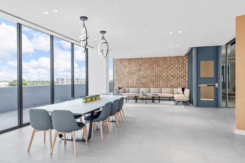 A modern dining room with a long table and chairs.