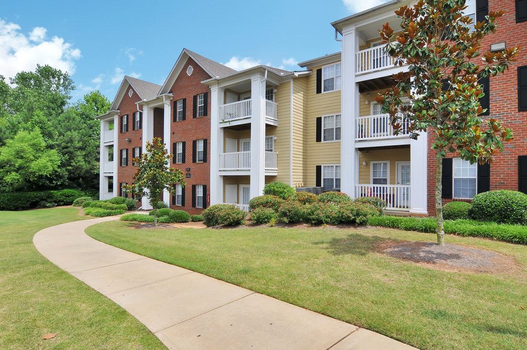Exterior of apartment with a grass area and flower bed by the building