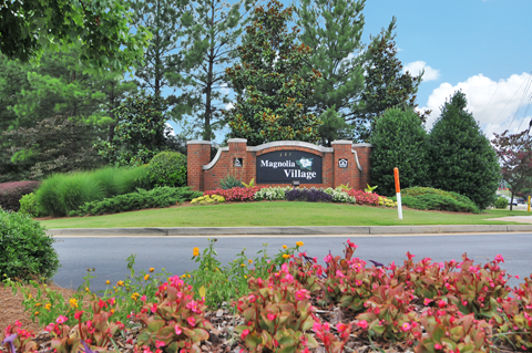 Community sign in the middle of a flower bed.