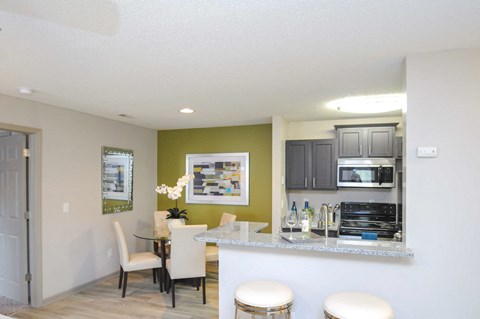 A kitchen with a table and chairs in it.