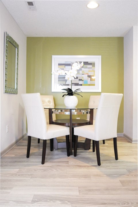 A dining room with a table and chairs.