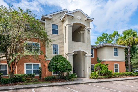 Apartment building exterior surrounded by native landscaping and parking lot