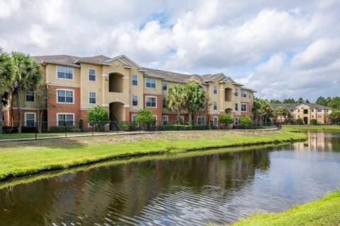 Apartment building exterior surrounded by native landscaping overlooking lake