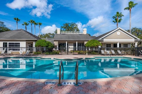 Leasing Office Exterior with Swimming Pool and Sun Deck with Lounge Chairs with Trees in the Background