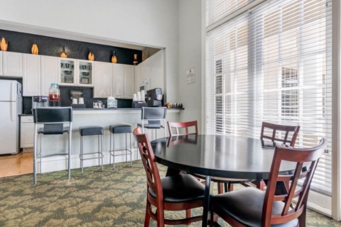 A kitchen with a bar area and a dining table.