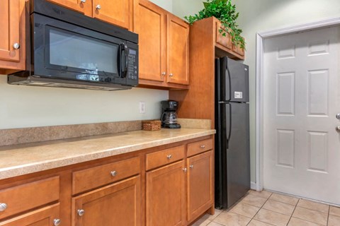 a kitchen with wooden cabinets and a black refrigerator