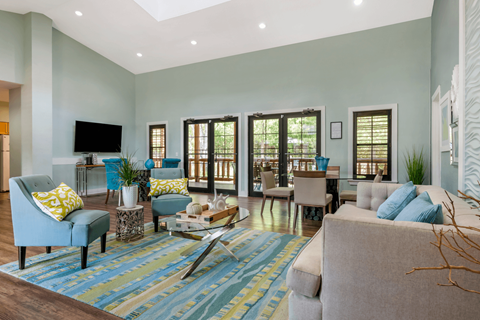 Clubhouse Lounge with couches, chairs, coffee table, television, and windows for natural lighting