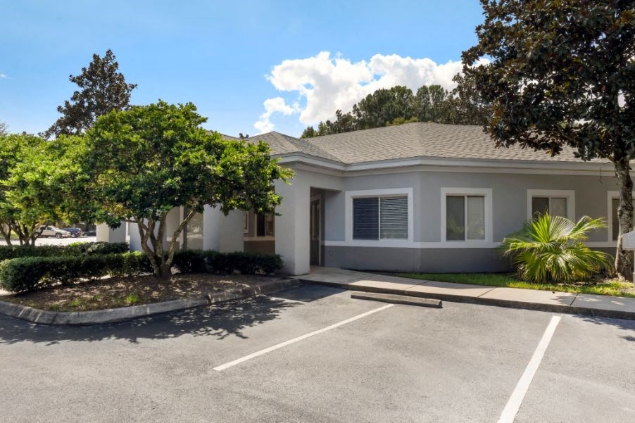 Leasing office exterior with native landscaping and parking lot