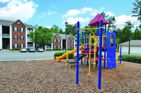 A playground with a blue and yellow slide and a red and yellow tower.
