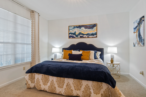 A bedroom with a large bed and a painting on the wall.