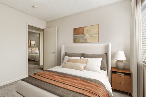 a bedroom with a bed and a nightstand with a lamp
