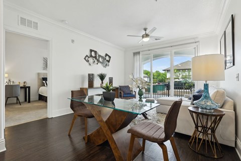 A modern dining room with a glass table and chairs.