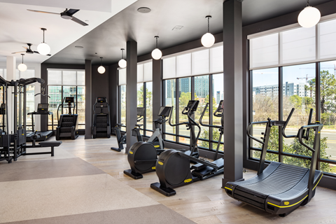 A gym with treadmills, elliptical machines, and other exercise equipment.