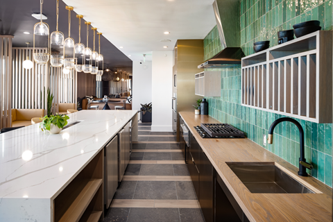 A modern kitchen with a long counter and a sink.