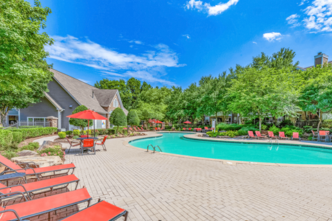 a swimming pool with chaise lounge chairs and trees in the background at Elan at Mallard Creek Apartment Homes, Charlotte, NC