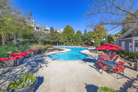 a pool with lounge chairs and umbrellas at the enclave at woodbridge apartments in sugar at Elan at Mallard Creek Apartment Homes, North Carolina, 28269