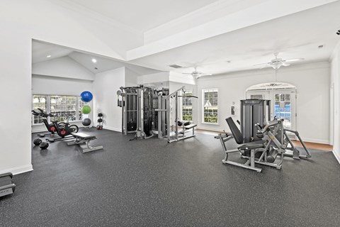 A spacious gym with a variety of equipment including a treadmill, weights, and a bench press at Elan at Mallard Creek Apartment Homes, Charlotte, 28269