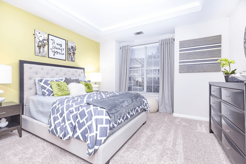 a bedroom with a large bed and a dresser at Elan at Mallard Creek Apartment Homes, Charlotte