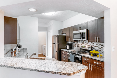 a kitchen with granite countertops and wooden cabinets at Elan at Mallard Creek Apartment Homes, Charlotte, 28269