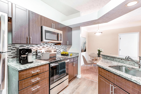 a kitchen with wooden cabinets and stainless steel appliances at Elan at Mallard Creek Apartment Homes, Charlotte, North Carolina