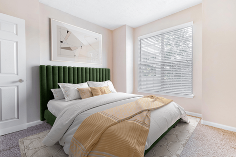 a bedroom with a bed and two windows at Elan at Mallard Creek Apartment Homes, North Carolina