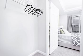 A white bedroom with a bed and a white wall at Elan at Mallard Creek Apartment Homes, North Carolina