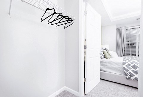 A white bedroom with a bed and a white wall at Elan at Mallard Creek Apartment Homes, North Carolina