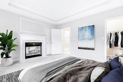 A bedroom with a large bed and a fireplace.