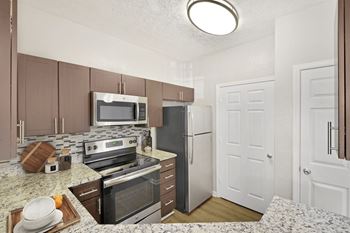 A kitchen with a refrigerator, oven, and microwave at Elan at Mallard Creek Apartment Homes, Charlotte, North Carolina