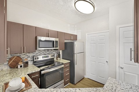 A kitchen with a refrigerator, oven, and microwave at Elan at Mallard Creek Apartment Homes, Charlotte, NC, 28269