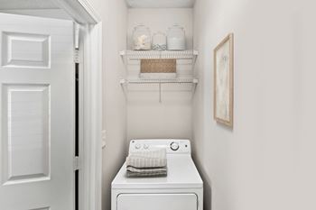 A white washing machine sits in a small laundry room at Elan at Mallard Creek Apartment Homes, Charlotte